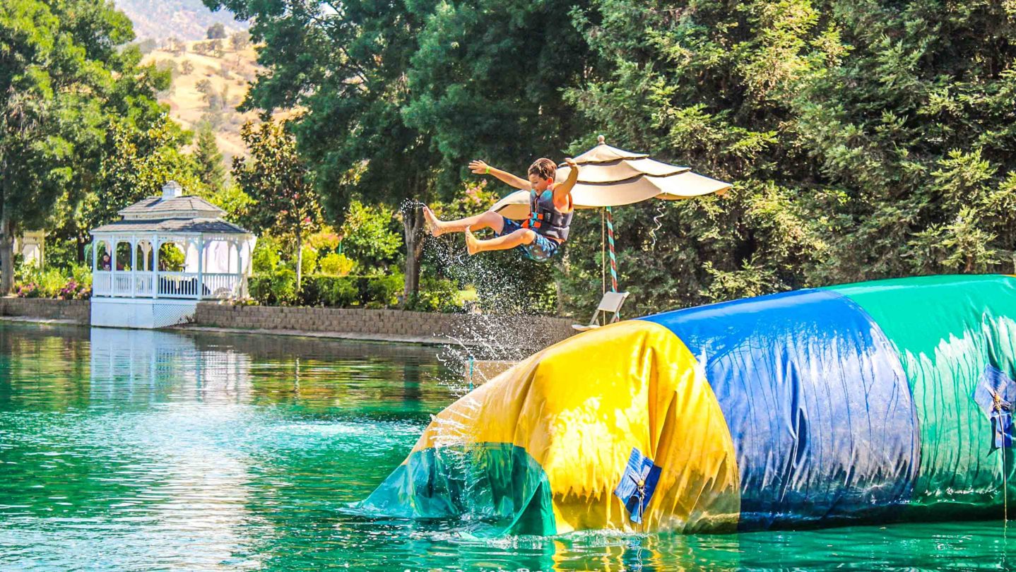 A camper jumping on an inflatable bouncy trampoline